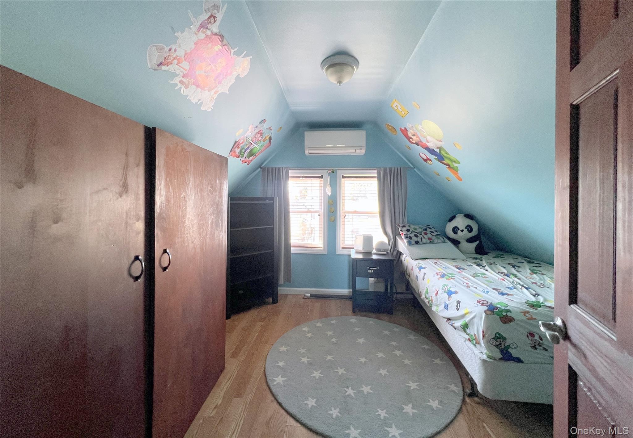 67-31 52nd Road Queens, NY 11378 - Photo 12 of 21 Bedroom featuring lofted ceiling, light wood-style flooring, and a wall mounted air conditioner