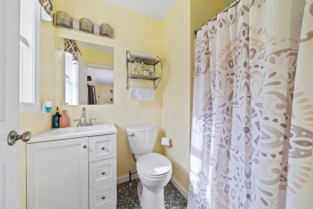 10 Crossman Circle Abington, MA 02351 - Photo 17 of 38 a bathroom with a toilet sink vanity and mirror