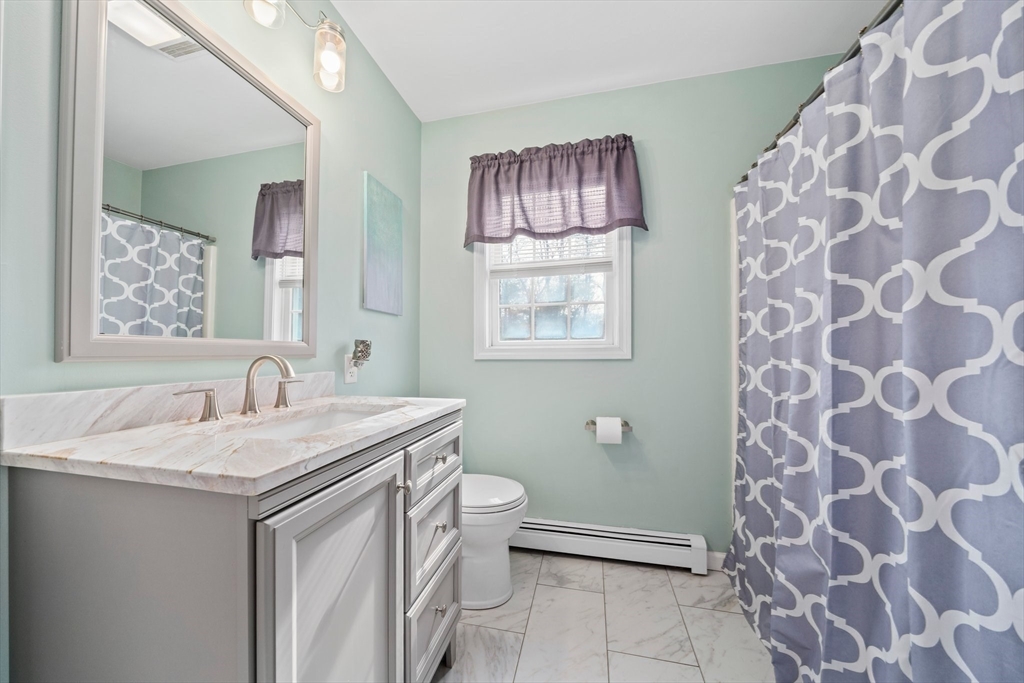 10 Crossman Circle Abington, MA 02351 - Photo 21 of 38 a bathroom with a granite countertop sink a toilet and a mirror