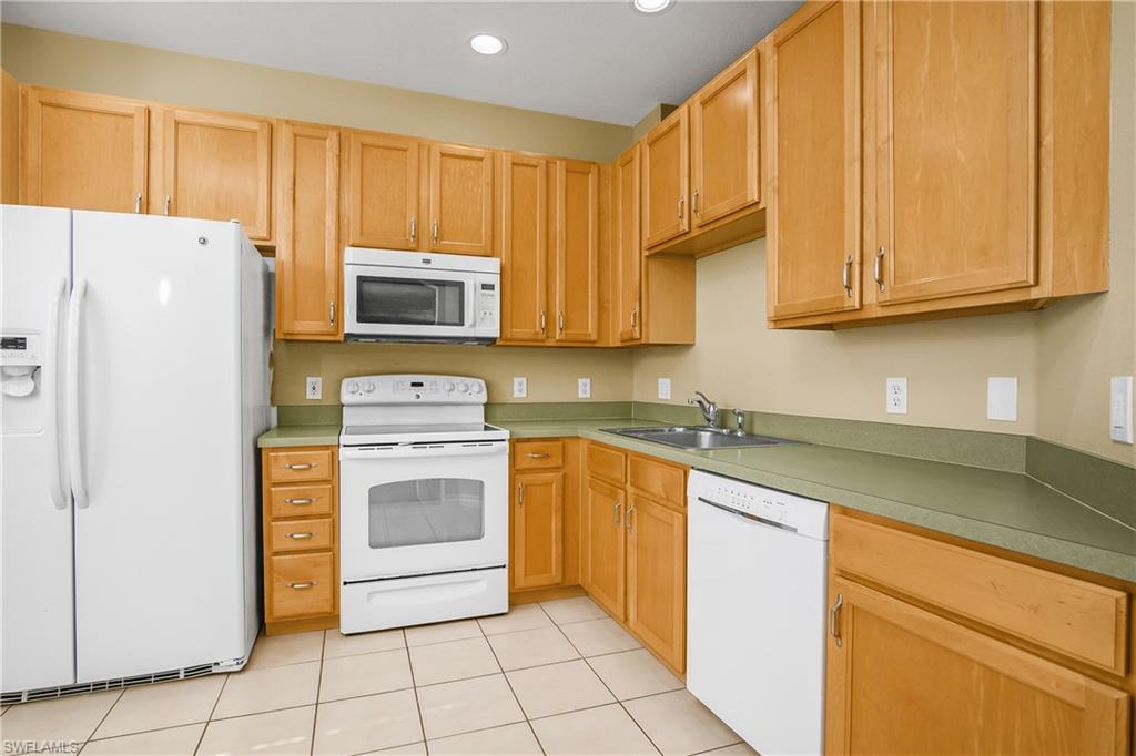 7820 Sandpine Court, Unit 2304 Naples, FL 34104 - Photo 12 of 49 a kitchen with granite countertop cabinets and steel stainless steel appliances with cabinets