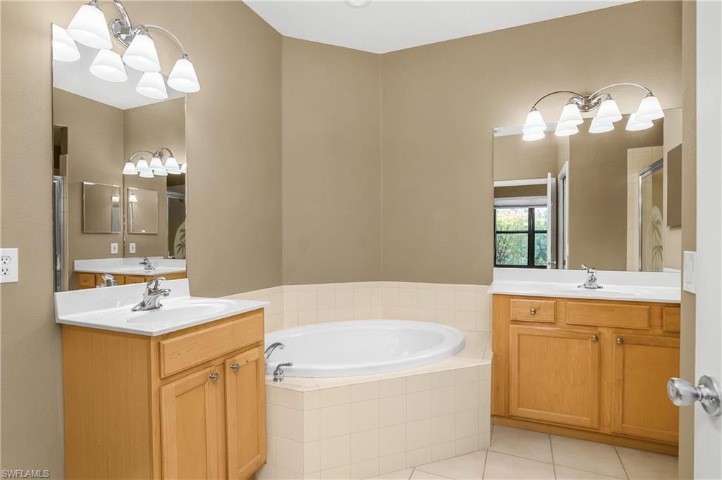 7820 Sandpine Court, Unit 2304 Naples, FL 34104 - Photo 19 of 49 a bathroom with a sink and a mirror