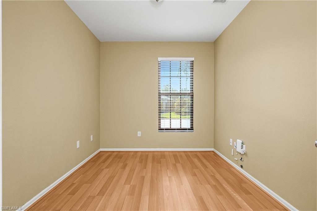 7820 Sandpine Court, Unit 2304 Naples, FL 34104 - Photo 26 of 49 a view of an empty room with wooden floor and a window