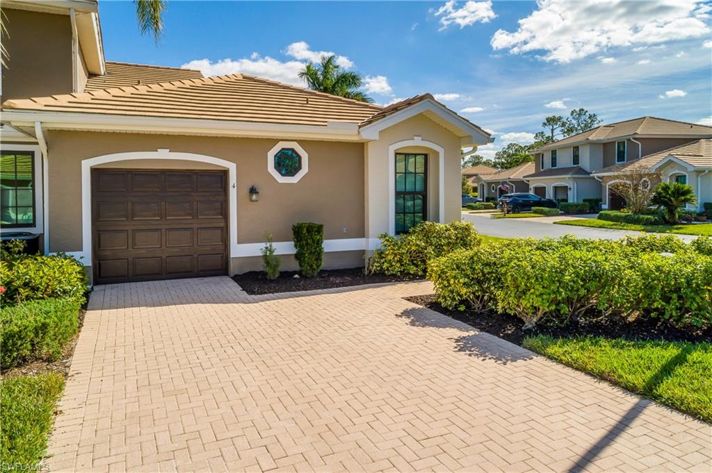 7820 Sandpine Court, Unit 2304 Naples, FL 34104 - Photo 32 of 49 a front view of a house with a yard and garage