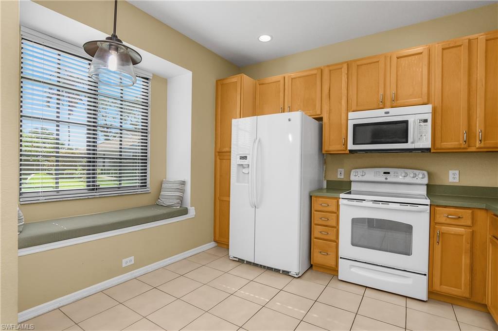 7820 Sandpine Court, Unit 2304 Naples, FL 34104 - Photo 9 of 49 a kitchen with a refrigerator and a stove top oven