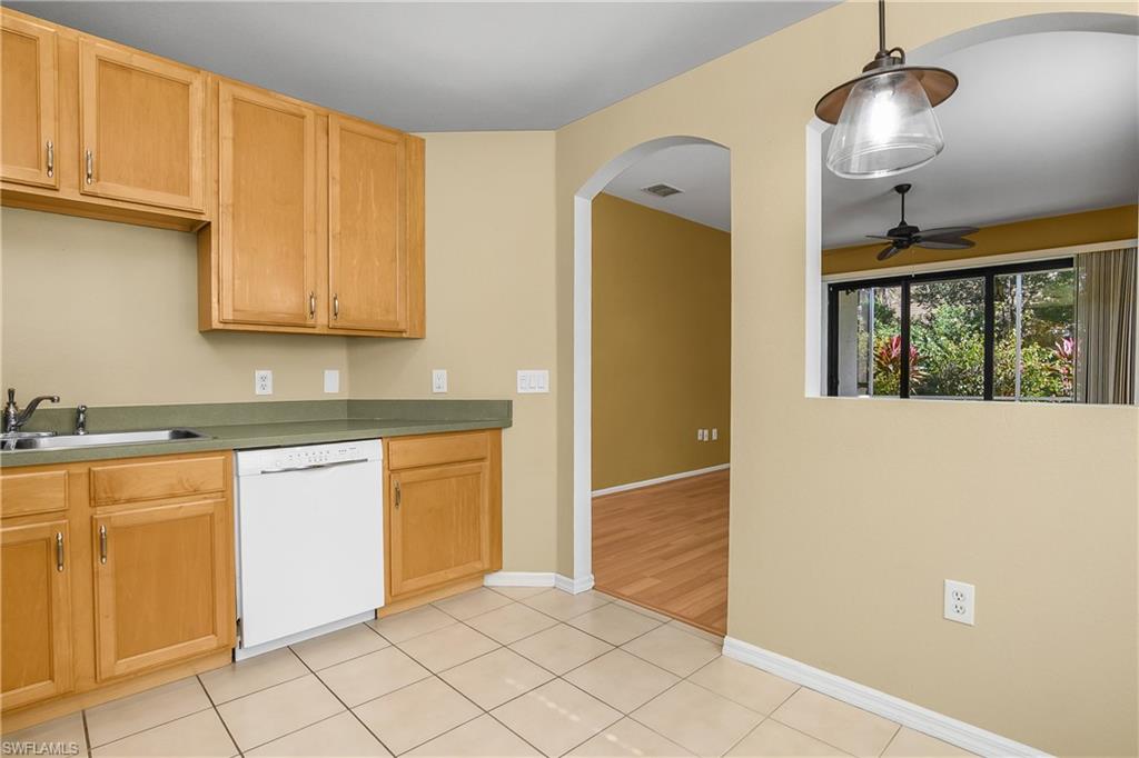 7820 Sandpine Court, Unit 2304 Naples, FL 34104 - Photo 10 of 49 a kitchen with granite countertop cabinets and refrigerator