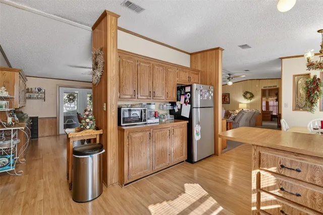 a kitchen with stainless steel appliances granite countertop a refrigerator a stove and a wooden floors