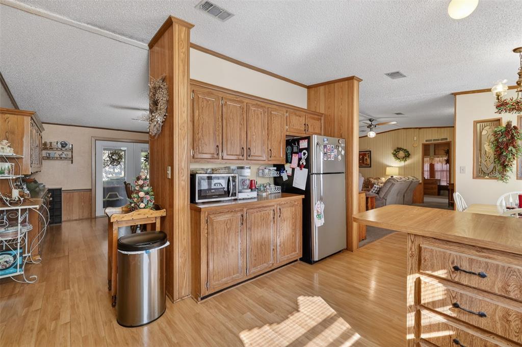 11911 Lane Park Road Tavares, FL 32778 - Photo 12 of 30 a kitchen with stainless steel appliances granite countertop a refrigerator a stove and a wooden floors