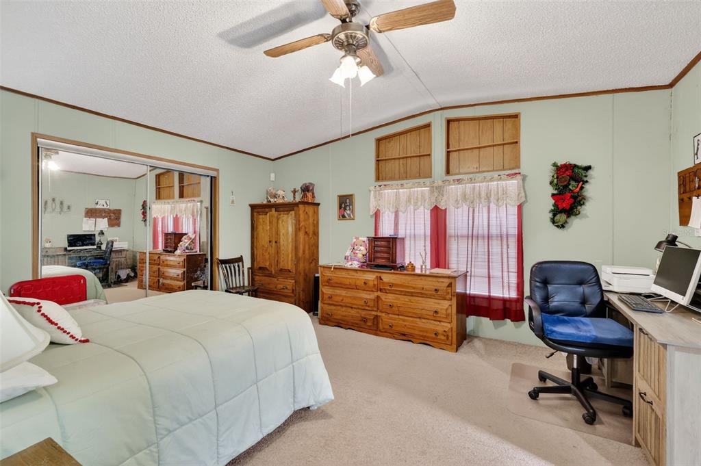 11911 Lane Park Road Tavares, FL 32778 - Photo 14 of 30 a bedroom with a bed and furniture