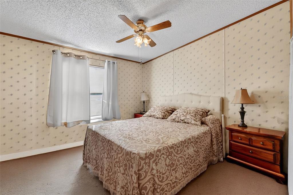 11911 Lane Park Road Tavares, FL 32778 - Photo 15 of 30 a bedroom with a bed and a ceiling fan with wooden floor