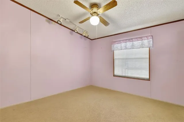 an empty room with a window and a fan