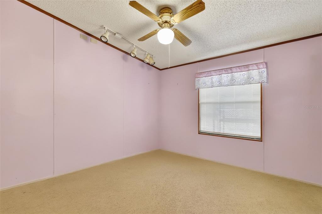 11911 Lane Park Road Tavares, FL 32778 - Photo 16 of 30 an empty room with a window and a fan