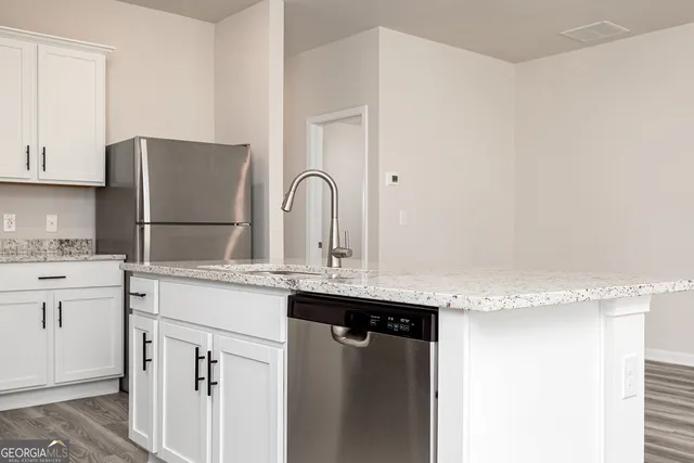 a kitchen with granite countertop a sink stainless steel appliances and cabinets