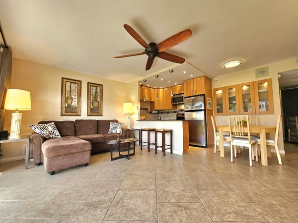 a living room with furniture a kitchen view and a dining table