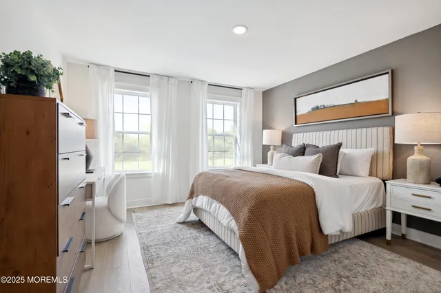 a bedroom with a bed a mirror and a large window