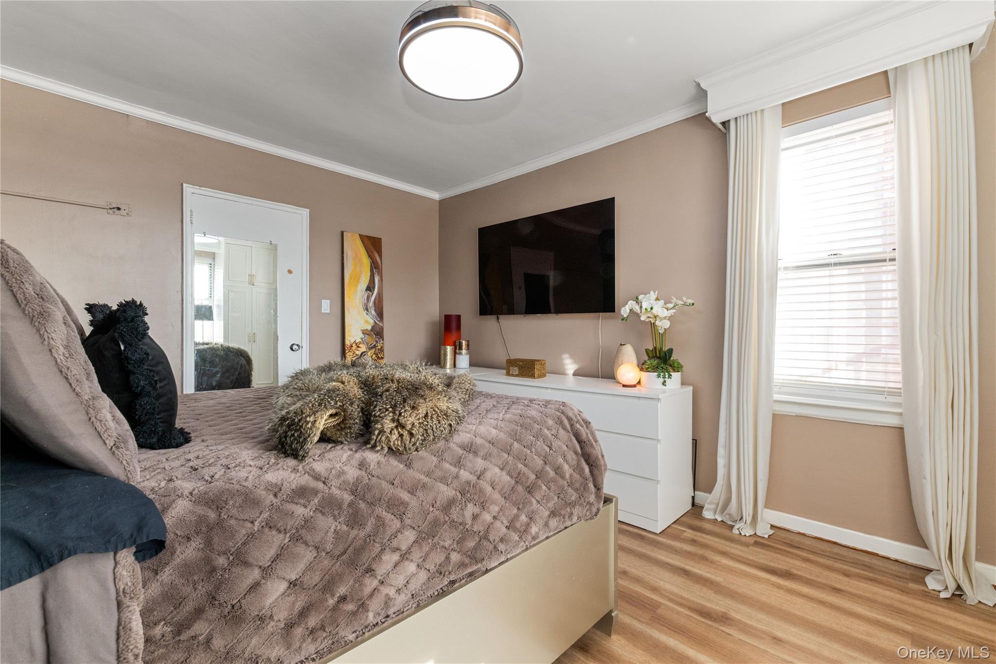 83-33 Austin Street, Unit 3D Queens, NY 11415 - Photo 12 of 20 a bedroom with a large bed and a flat tv screen on dresser