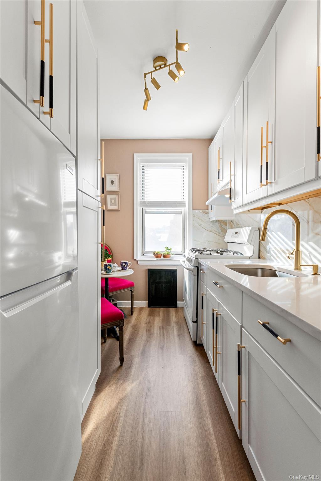 83-33 Austin Street, Unit 3D Queens, NY 11415 - Photo 7 of 20 a kitchen with a refrigerator a sink dishwasher and a stove with wooden floor