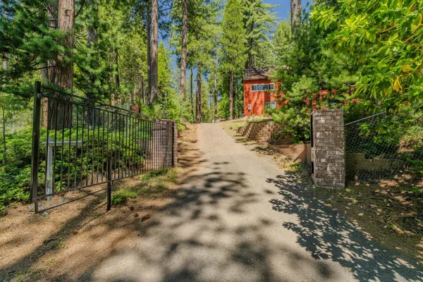 a backyard of a house with swimming pool and large trees