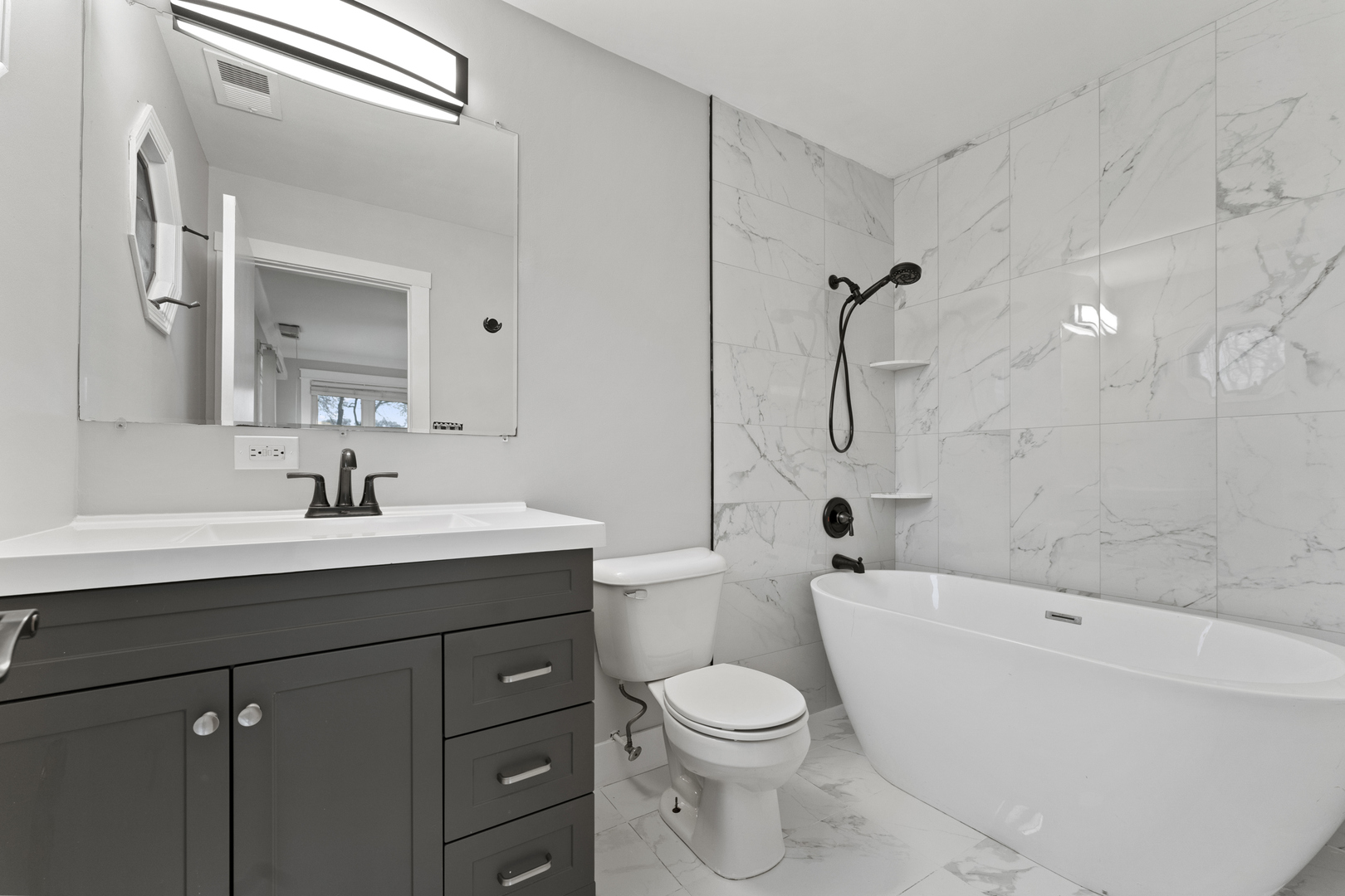 8306 South 82nd Avenue Justice, IL 60458 - Photo 16 of 40 a bathroom with a bathtub shower sink vanity mirror and toilet