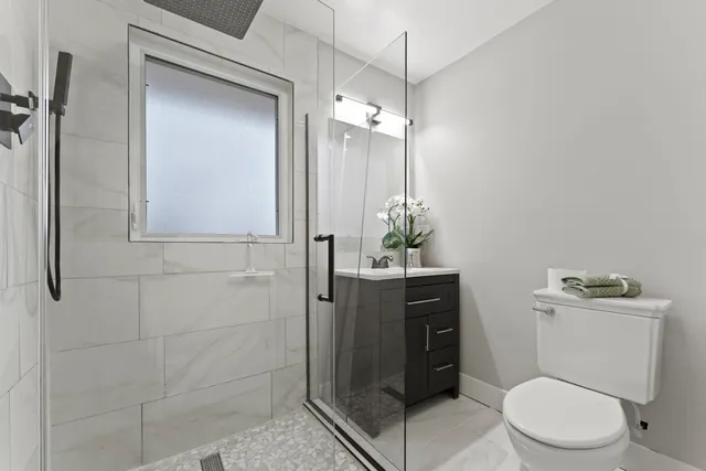 a bathroom with a toilet a sink and shower