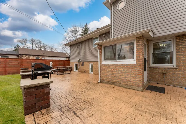 a backyard of a house with barbeque oven and outdoor seating