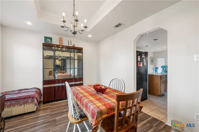 a dining room with furniture a chandelier and wooden floor