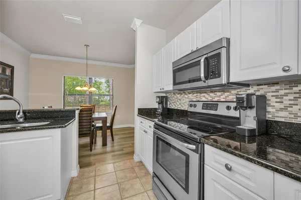 a kitchen with stainless steel appliances granite countertop a stove a sink and a microwave