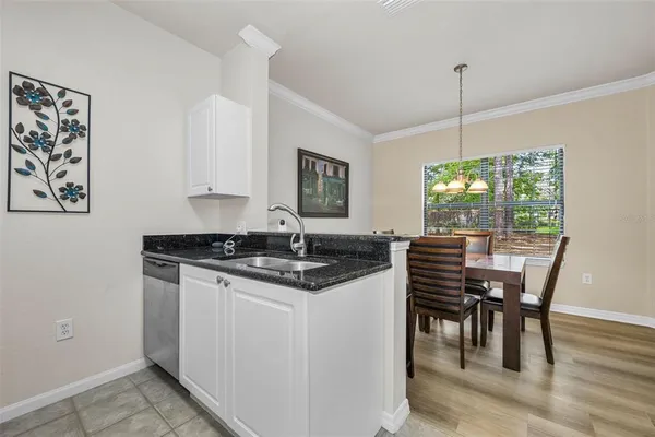a kitchen with a stove a sink a dining table and chairs