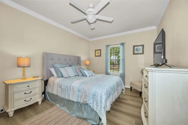a bedroom with a bed and a flat tv screen on dresser