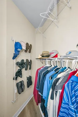 a view of walk in closet with clothes and shoes