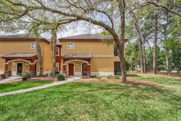 a view of a big house with a big yard and large tree