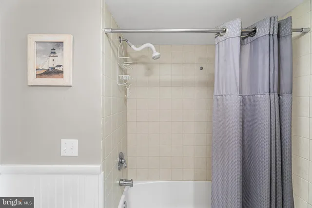 a bedroom with a bed and a lamp on dresser