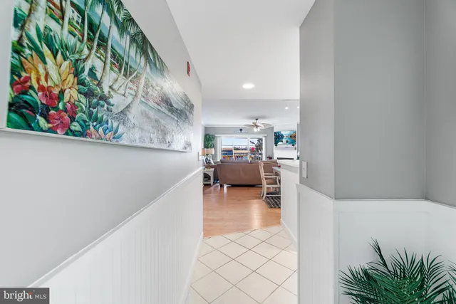 a large white kitchen with stainless steel appliances granite countertop a sink and dishwasher a stove top oven with wooden floor