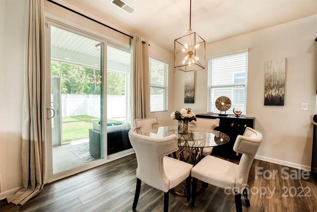 14015 Ridgewater Way Charlotte, NC 28278 - Photo 14 of 48 a dining room with wooden floor a chandelier a glass table and chairs