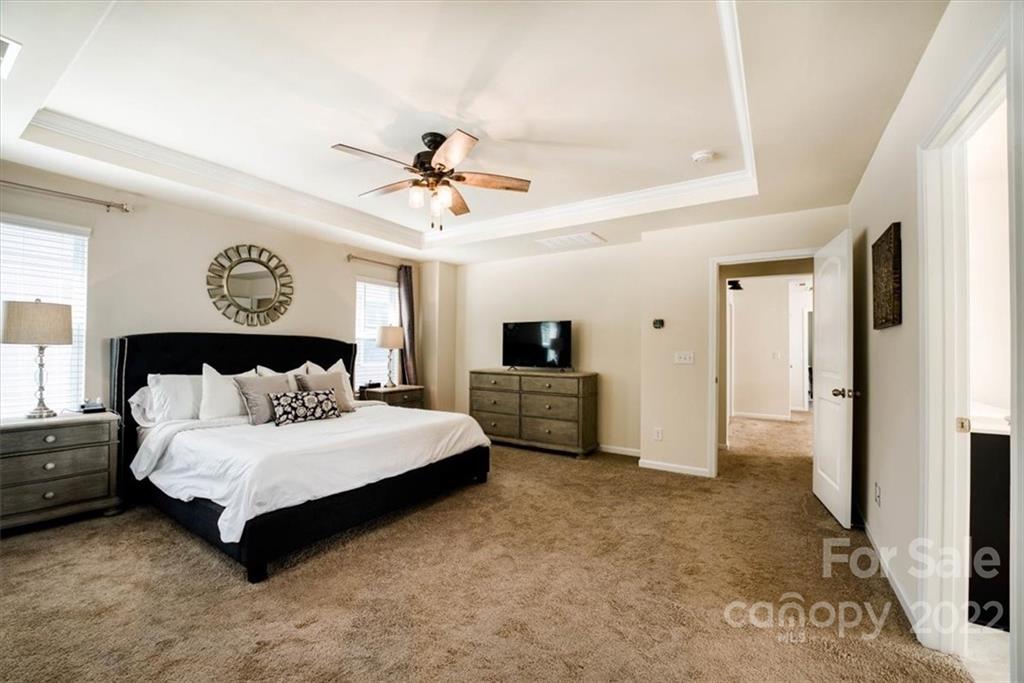 14015 Ridgewater Way Charlotte, NC 28278 - Photo 34 of 48 a spacious bedroom with a bed a couch and a flat tv screen