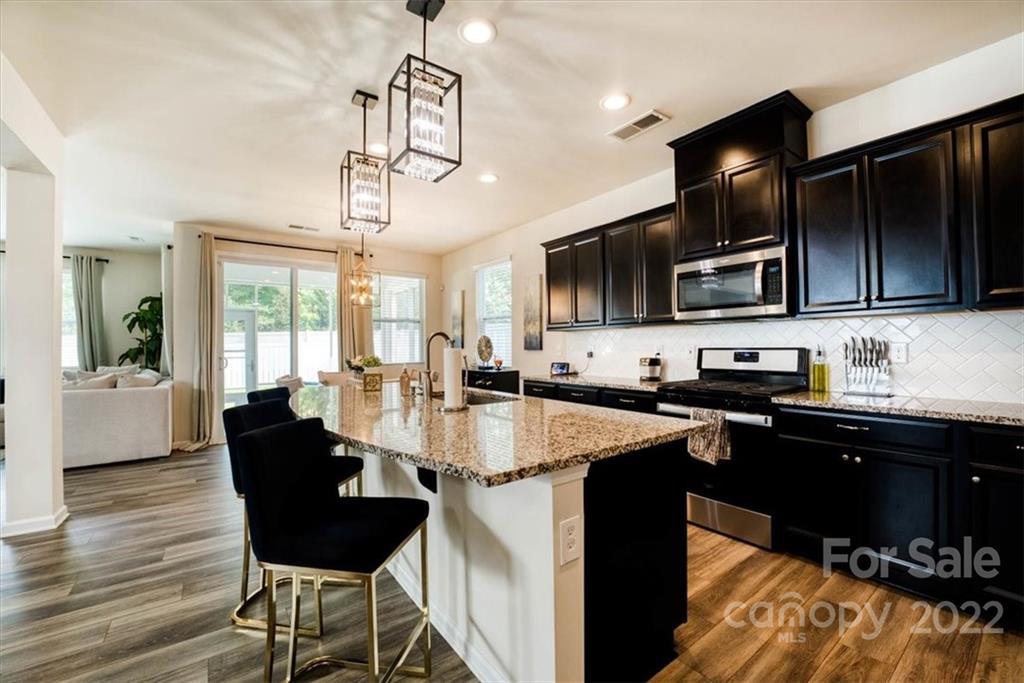 14015 Ridgewater Way Charlotte, NC 28278 - Photo 8 of 48 a kitchen with stainless steel appliances granite countertop a sink dishwasher a stove refrigerator and cabinets with wooden floor