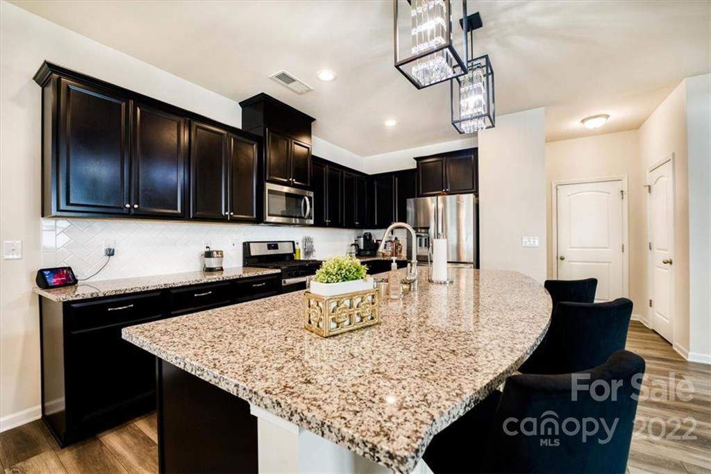 14015 Ridgewater Way Charlotte, NC 28278 - Photo 9 of 48 a kitchen with a stove center island cabinets and furniture