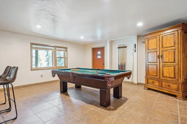a room with furniture pool table and windows
