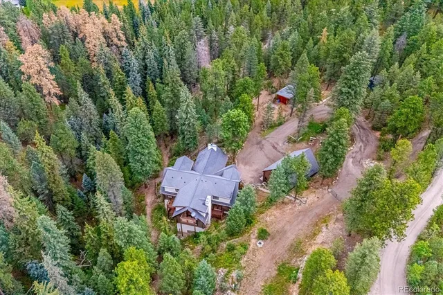 an aerial view of a house with a yard and greenery