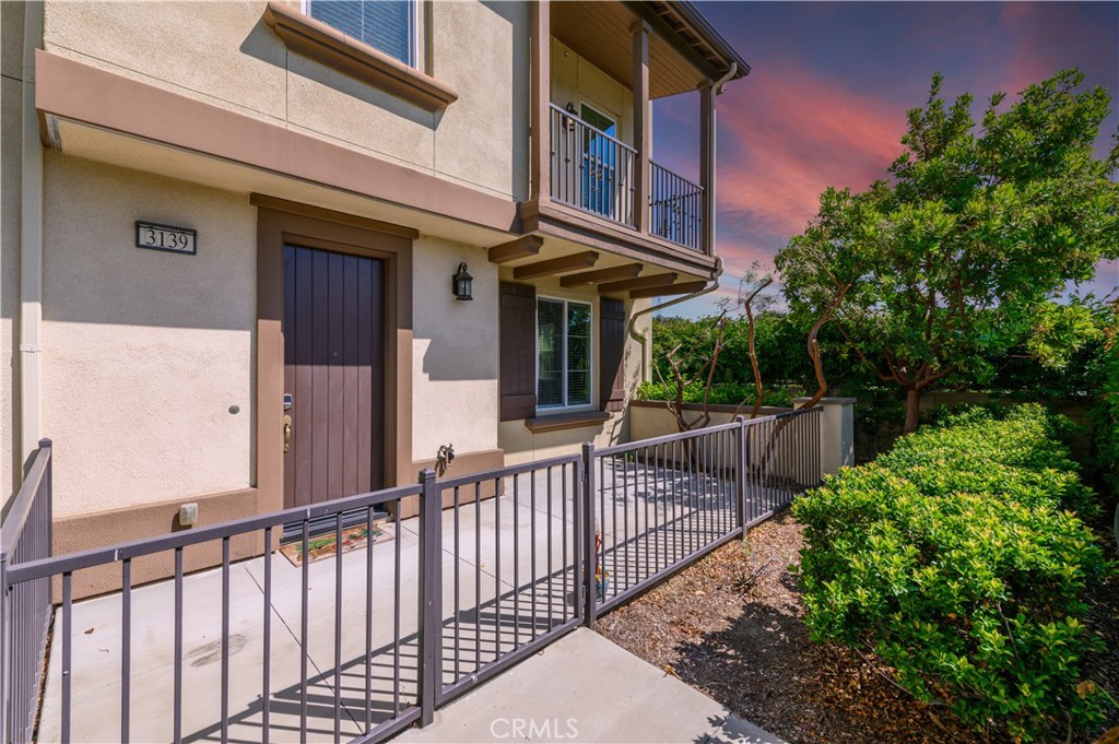 a view of a house with large windows and plants