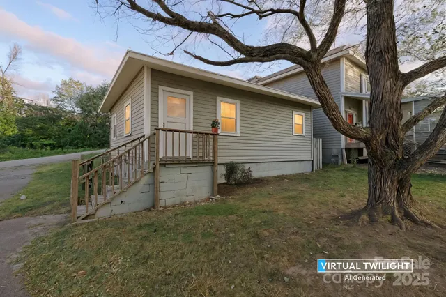 a view of a house with a yard and large tree