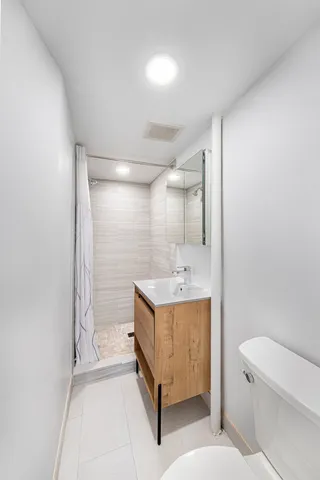 a bathroom with a sink a toilet and shower