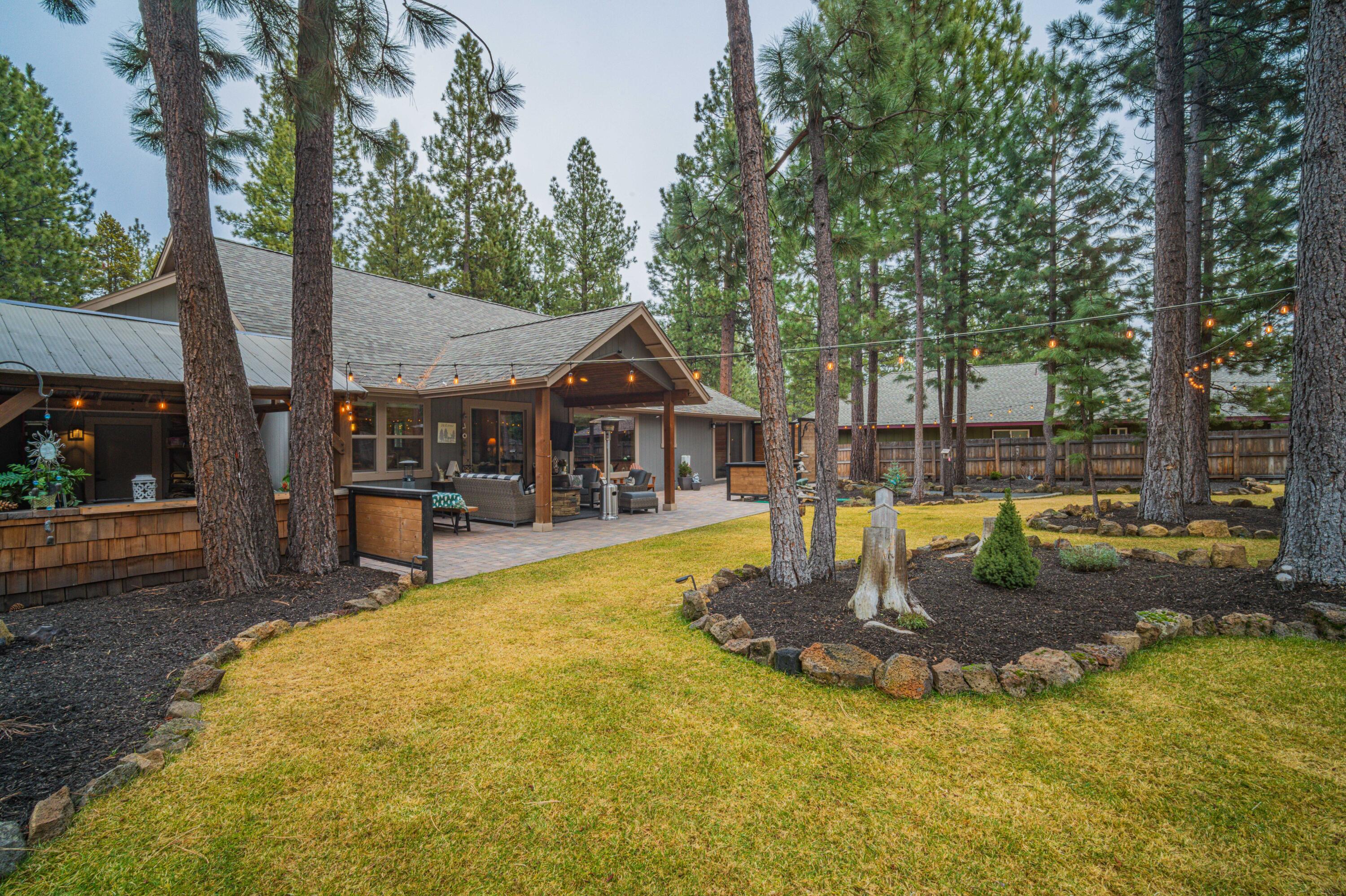16927 Covina Road Bend, OR 97707 - Photo 36 of 54 Sweeping view of the backyard oasis with mature pines, expansive lawn, and thoughtfully designed outdoor living spaces that make this property truly exceptional.