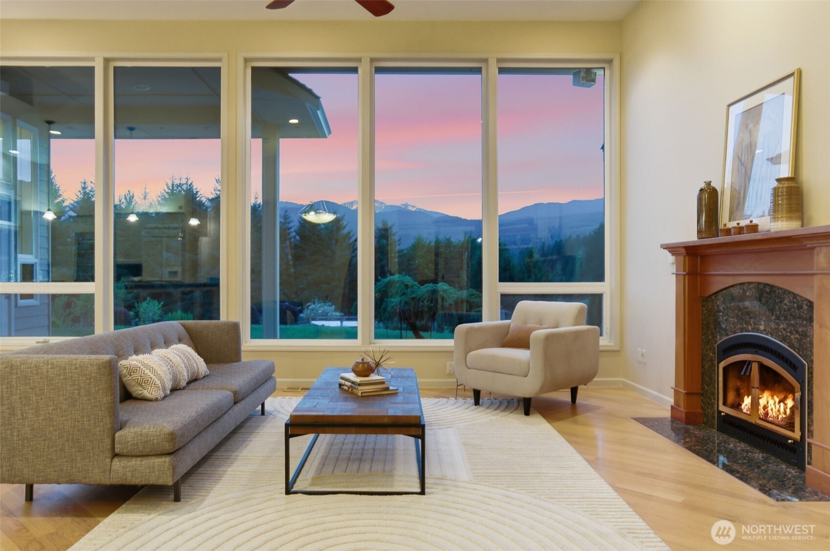 2263 Lost Mountain Road Sequim, WA 98382 - Photo 2 of 40 a living room with furniture a fireplace and a floor to ceiling window