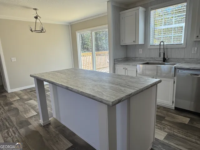 a kitchen with granite countertop a sink window and cabinets