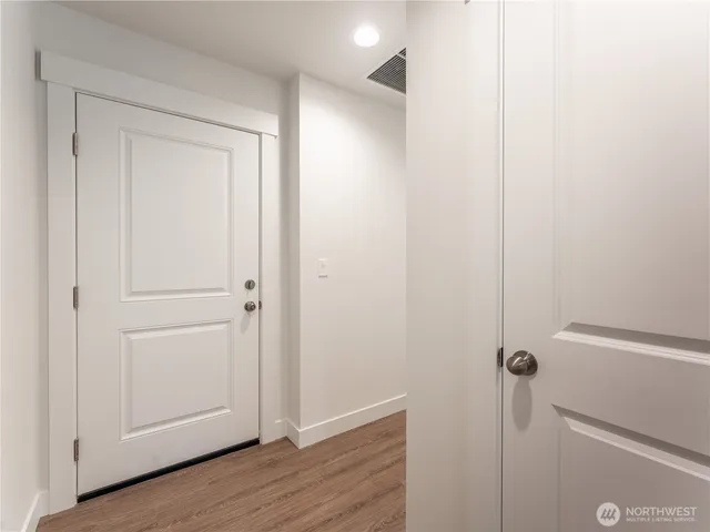 a view of a hallway with wooden floor