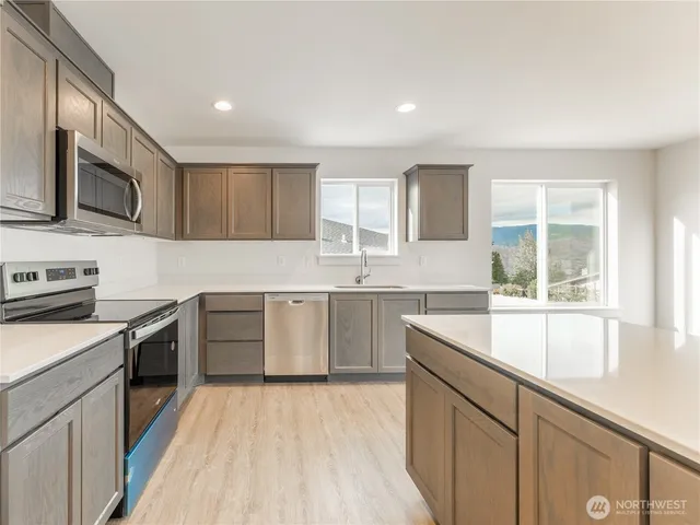 a kitchen with a sink stove top oven and microwave