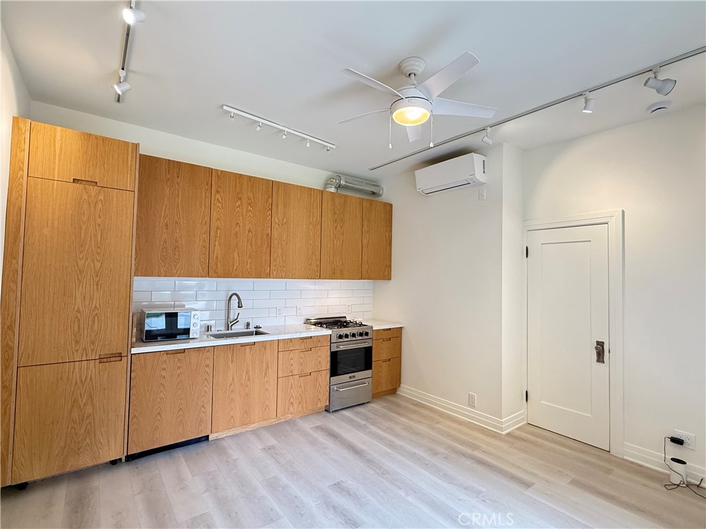 a kitchen with stainless steel appliances a sink a stove a refrigerator and cabinets