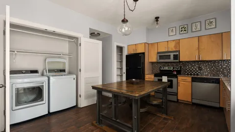 a kitchen with a refrigerator and a stove top oven