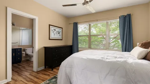 a bedroom with a bed and a large window
