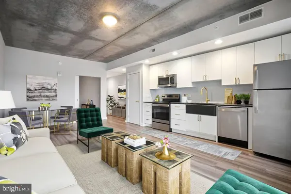 a kitchen with stainless steel appliances kitchen island granite countertop a stove a refrigerator a sink dishwasher a dining table and chairs with wooden floor